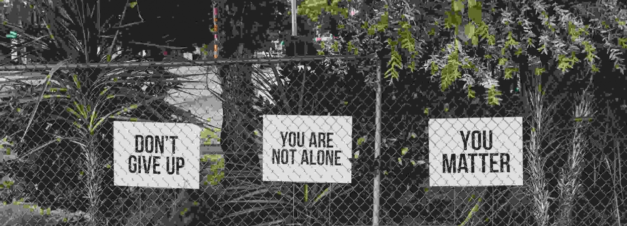 mental health marketing phrases displayed on a fence