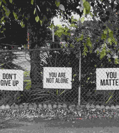 mental health marketing phrases displayed on a fence