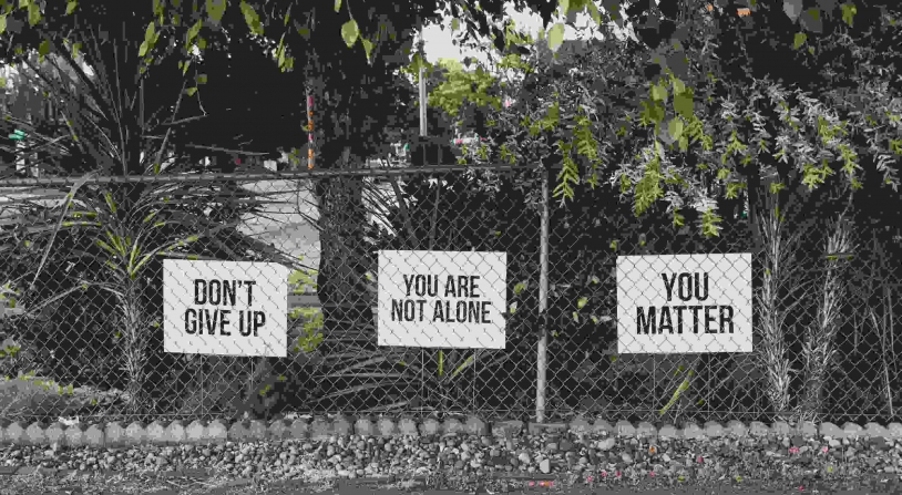 mental health marketing phrases displayed on a fence