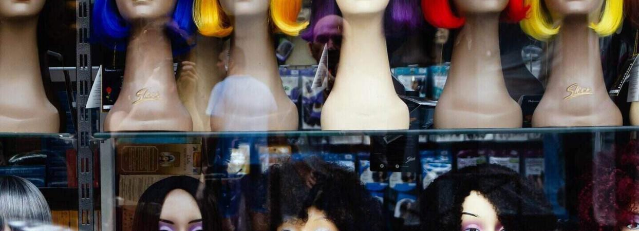 wigs with different hairstyles in a window