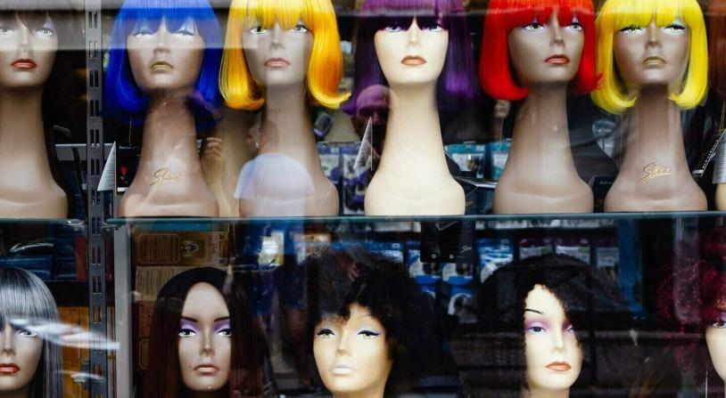 wigs with different hairstyles in a window