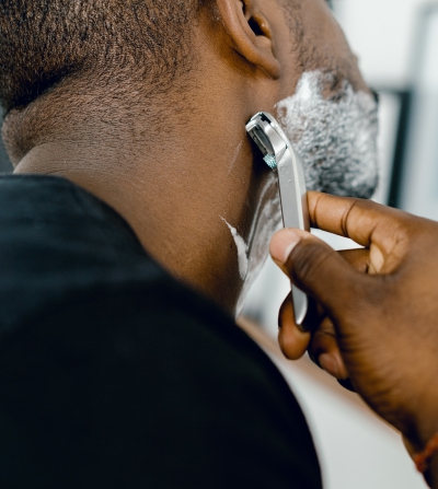 man shaving his beard using grooming products