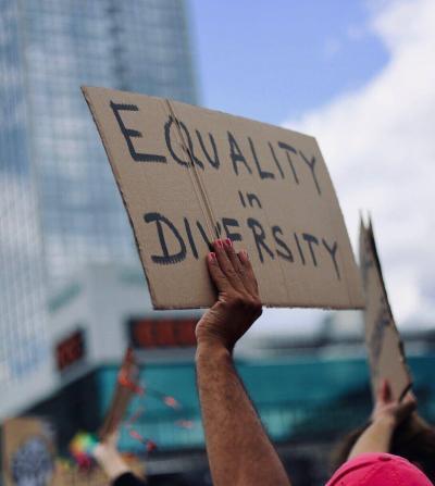 woman holding sign that says equality in diversity