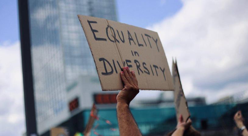 woman holding sign that says equality in diversity