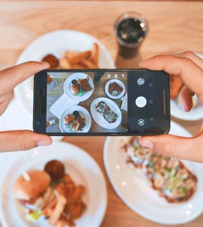 food influencer taking a picture of food on a table