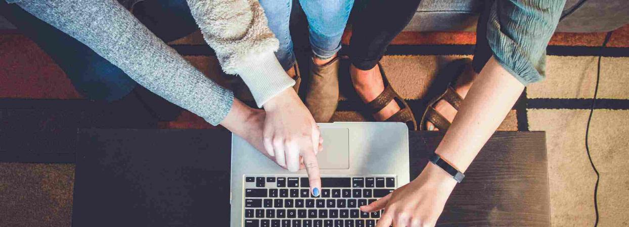 women pointing to a laptop screen