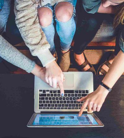 women pointing to a laptop screen