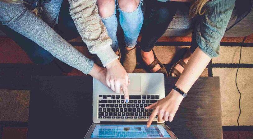 women pointing to a laptop screen