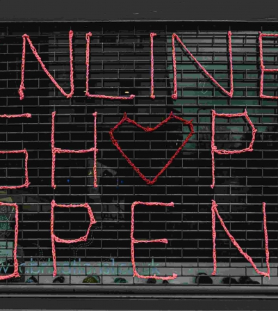 closed storefront with a sign that says online shop open