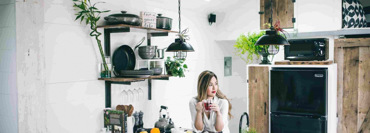 woman sitting in a kitchen next to small home appliances