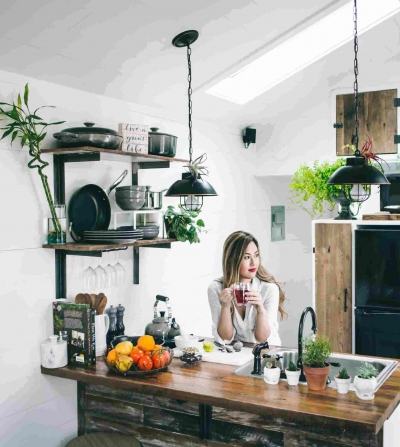 woman sitting in a kitchen next to small home appliances