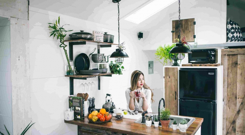 woman sitting in a kitchen next to small home appliances